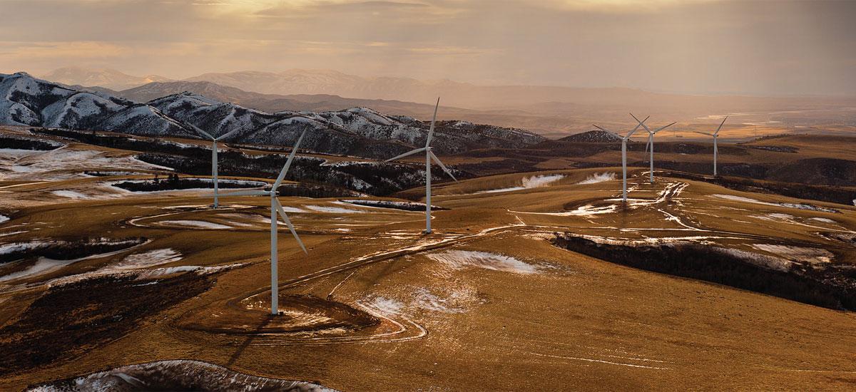 wind turbines on top of snowy desert mountains