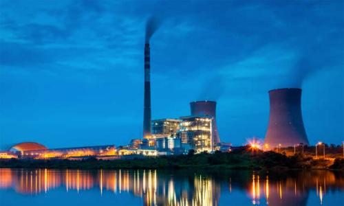 Power plant at dusk with reflection on water