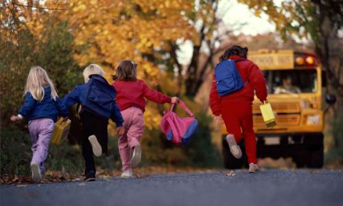 Children running to catch a school bus