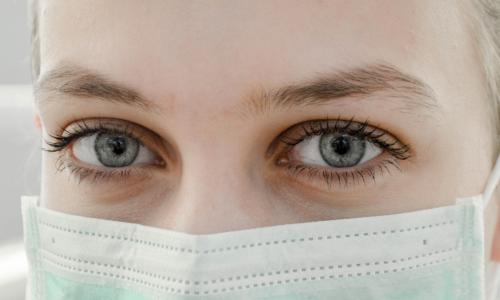 A closeup of a person wearing a protective mask.