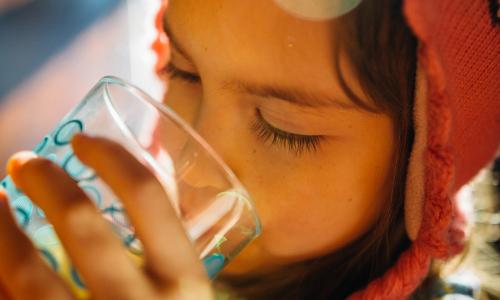 Child drinking glass of water.