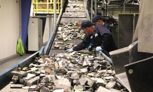 A conveyor belt sends lithium ion batteries to be shredded