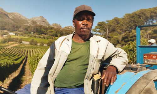 man on tractor in front of farm