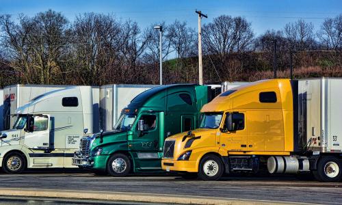 line of semi trucks in parking lot