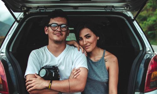 A couple standing in front of a car with open liftgate