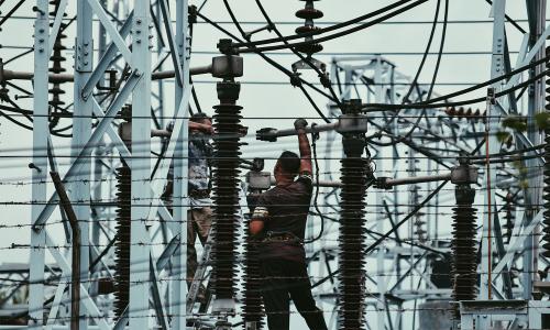 men repairing checking electric lines at station