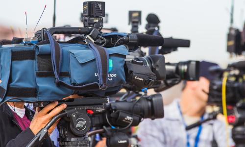 A line of reporters holding video cameras.