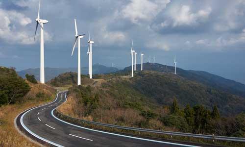 A road winding through wind turbines