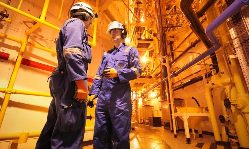 Two workers inside of a nuclear power plant.