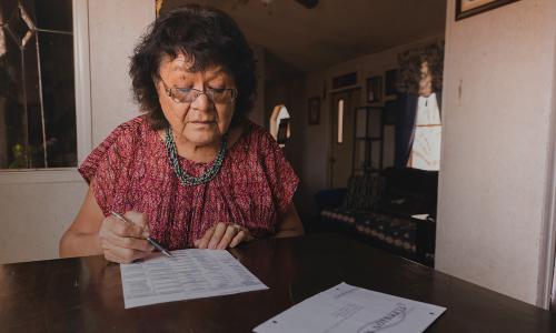 Person filling out a mail-in voting ballot.