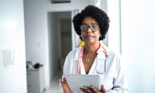 A doctor holding an iPad.