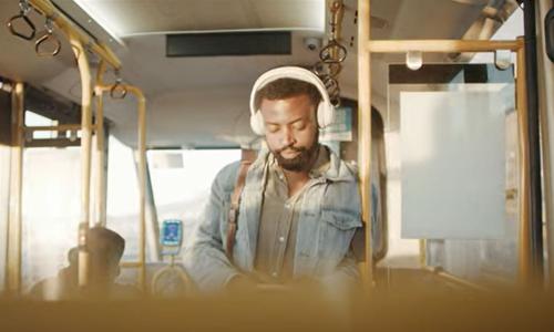 man with headphones riding a bus