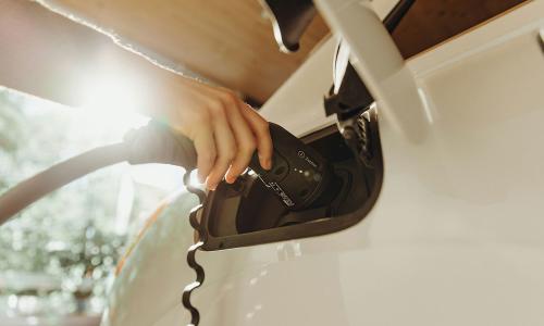 Person charging a white EV